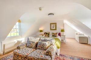 een slaapkamer met een bed en een bank op zolder bij 13 Bed in Skendleby oc-s33954 in Skendleby