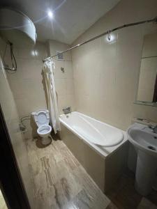 een badkamer met een bad, een toilet en een wastafel bij SINGAPOUR MAROC in Casablanca