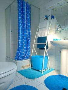 y baño con cortina de ducha azul, aseo y lavamanos. en BnB Heimdall en Brecht