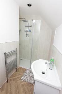 een badkamer met een witte wastafel en een douche bij Modern 3 bedroom home refurbished with parking in Wednesbury +17 foto's