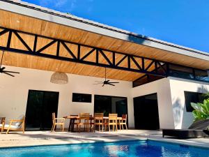 a patio with a table and chairs next to a pool at Honu Villas - Nui in Nosara