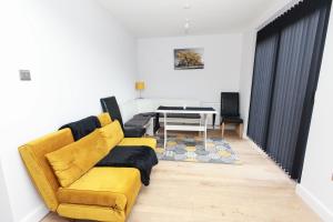 een woonkamer met een gele bank en een tafel bij Modern 3 bedroom home refurbished with parking in Wednesbury