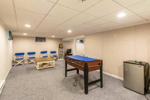een conferentieruimte met een tafeltennistafel en stoelen bij Spacious Home w Finished Game Room in Eastham
