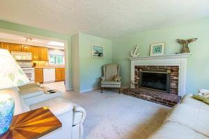 een woonkamer met een open haard en een witte bank bij Spacious Home w Finished Game Room in Eastham +21 foto's