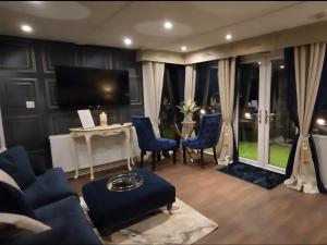 a living room with a table and chairs and a television at Mary Queen of Scots Lodge in Musselburgh