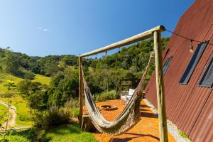 un'amaca appesa a un edificio accanto a un edificio di Chale Alcantara Jacuzzi, Lareira e Deck com Vista a São Pedro de Alcântara