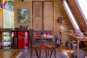 una cucina con un tavolo e un frigorifero rosso di Chale Alcantara Jacuzzi, Lareira e Deck com Vista a São Pedro de Alcântara