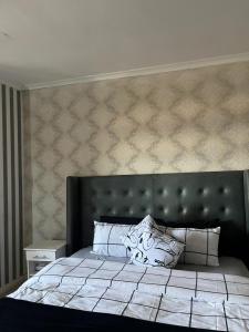 a bedroom with a large bed with a large headboard at Sleep easy at Peperboom in Kuilsrivier