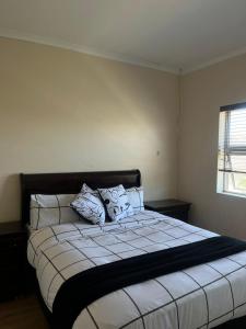 a bedroom with a large bed with pillows on it at Sleep easy at Peperboom in Kuilsrivier