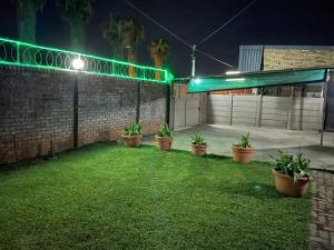 a yard with potted plants and a garage at night at Royal BNB and SPA in Zeerust