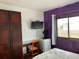 een slaapkamer met een bed, een tv en een raam bij Pousada La Marea in Rio Grande