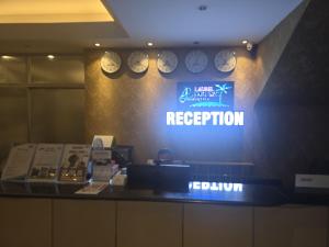 a sign for a restaurant with clocks on a wall at Laurel Lakefront Hotel in Dhaka