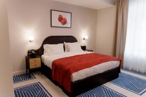 a bedroom with a large bed with a red blanket at Pana Unique Semey in Semey