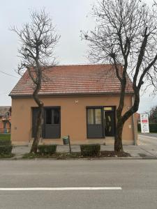 een huis met twee bomen aan de straatkant bij Studio apartman MARIA 2 