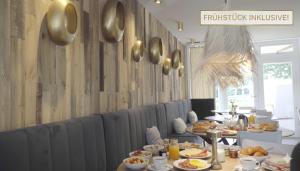 ein Esszimmer mit Tellern aus Essen auf Tischen in der Unterkunft Ferienanlage Landliebe Appartement 5 in Alkersum