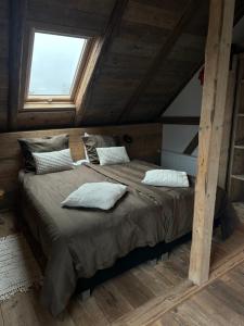 a large bed in a wooden room with a window at Tante Hanna in Winterberg