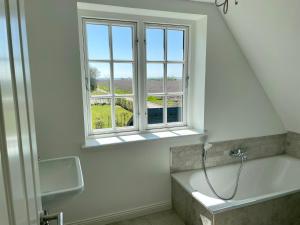 un bagno con vasca e finestra di Sommergeest a Goting
