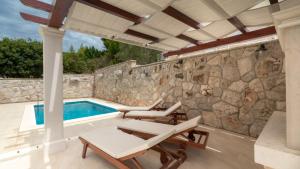 a patio with chairs and a swimming pool at Villa Vanilla by Villas Guide in Smokvica