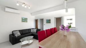 a living room with a table and red chairs at Villa Vanilla by Villas Guide in Smokvica