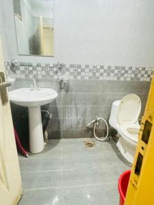 a bathroom with a sink and a toilet at Urban Suites in Faisalabad
