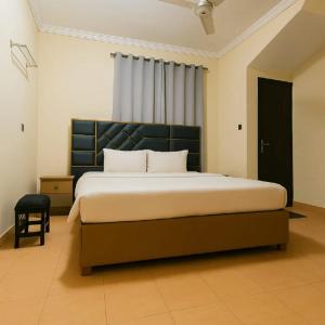 a bedroom with a large bed with a black headboard at Urban Suites in Faisalabad