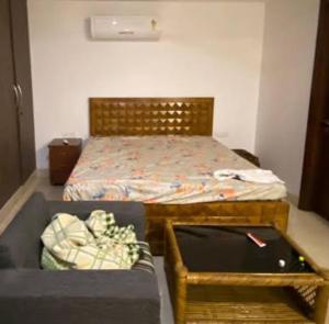 a bedroom with a bed with a table and a bed sidx sidx sidx at Urban Suites in Faisalabad