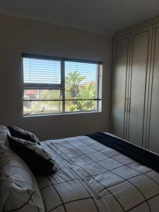 a bedroom with a large bed with a large window at Sleep easy at Peperboom in Kuilsrivier