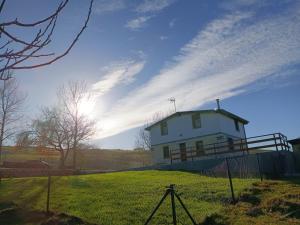 una casa bianca su una collina erbosa con una recinzione di La Tadorna a Suances