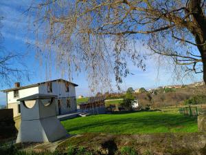 un edificio in un campo con un albero di La Tadorna a Suances