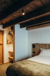 a bedroom with a bed and a wooden ceiling at Chalet du cerf fragment in Saint-Martin-de-Belleville