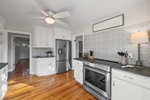 a kitchen with white cabinets and a ceiling fan at Nanas Nook on Hickory Grove in Clarksville