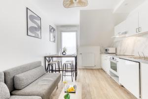 a living room with a couch and a kitchen at Cinéhouse, Proche Paris 5 min, 2 chambre in Bobigny