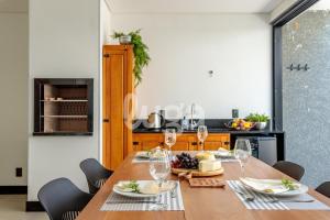 a dining room with a table with wine glasses at LUGA Relax House with Jacuzzi in Palhoça