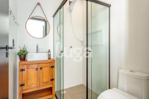 a bathroom with a glass shower and a sink at LUGA Relax House with Jacuzzi in Palhoça +10 photos