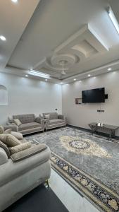 un soggiorno con divani e TV a schermo piatto di Mountain Breeze Stay a Sayq