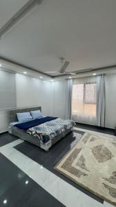 una camera con letto, finestra e tappeto di Mountain Breeze Stay a Sayq Altre 8 foto