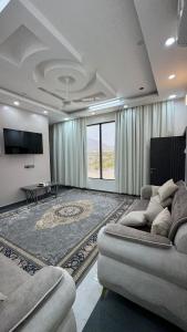 un soggiorno con divano e TV a schermo piatto di Mountain Breeze Stay a Sayq