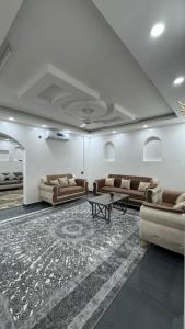 un soggiorno con divani, tavolo e tappeto di Mountain Breeze Stay a Sayq