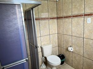 een kleine badkamer met toilet en douche bij Pousada La Marea in Rio Grande +52 foto's