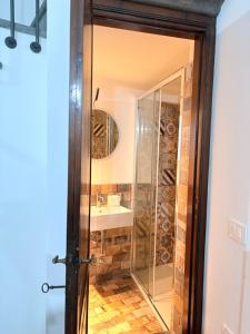 een badkamer met een glazen douche en een wastafel bij DIMORA MedioEvo in Orvieto