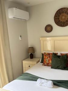 a bedroom with a bed and a air conditioner on the wall at Peter's Nest in Livingstone