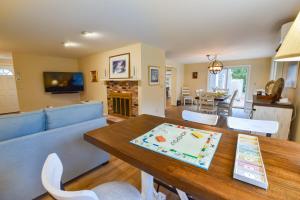 uma sala de jantar e sala de estar com mesa e cadeiras em Sunroom Mins to Beaches Views of Marsh em Eastham