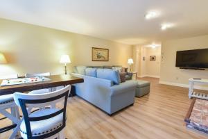 uma sala de estar com um sofá e uma mesa em Sunroom Mins to Beaches Views of Marsh em Eastham