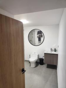 bagno con servizi igienici e specchio di Hotel La Casona Estadio a Medellín
