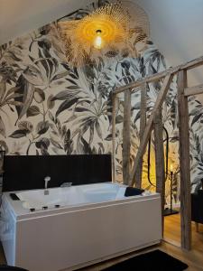 a bathroom with a bath tub in a room with floral wallpaper at Résidence ARTHUS Thamarys in Pierrefonds +12 photos