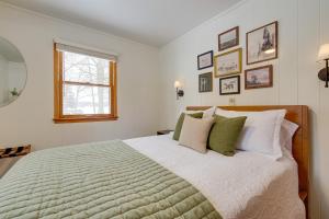 una camera da letto con un letto grande con cuscini verdi e bianchi di Waterfront Deck! Chic Lower Scott Lake Cottage a Pullman