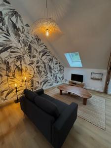 een woonkamer met een bank en een tafel bij Résidence ARTHUS Thamarys in Pierrefonds