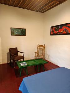 een woonkamer met een groene tafel en een stoel bij Koniminto Hostal in Pijao