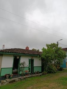 a green and white house with a green door at Koniminto Hostal in Pijao +8 photos