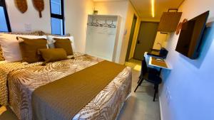a bedroom with a bed and a desk and a television at Hit Cabo Branco Flat Aconchego a 30 metros do mar in João Pessoa +59 photos